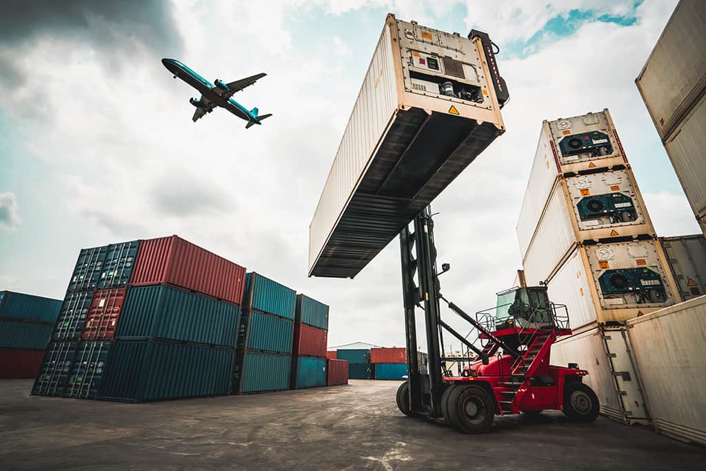 eCommerce cargo plane post takeoff with forklift hoisting container in the foreground.