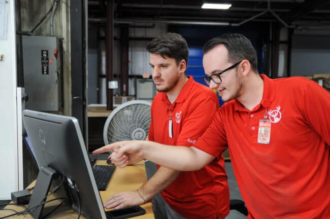 RedStag employees checking on computer