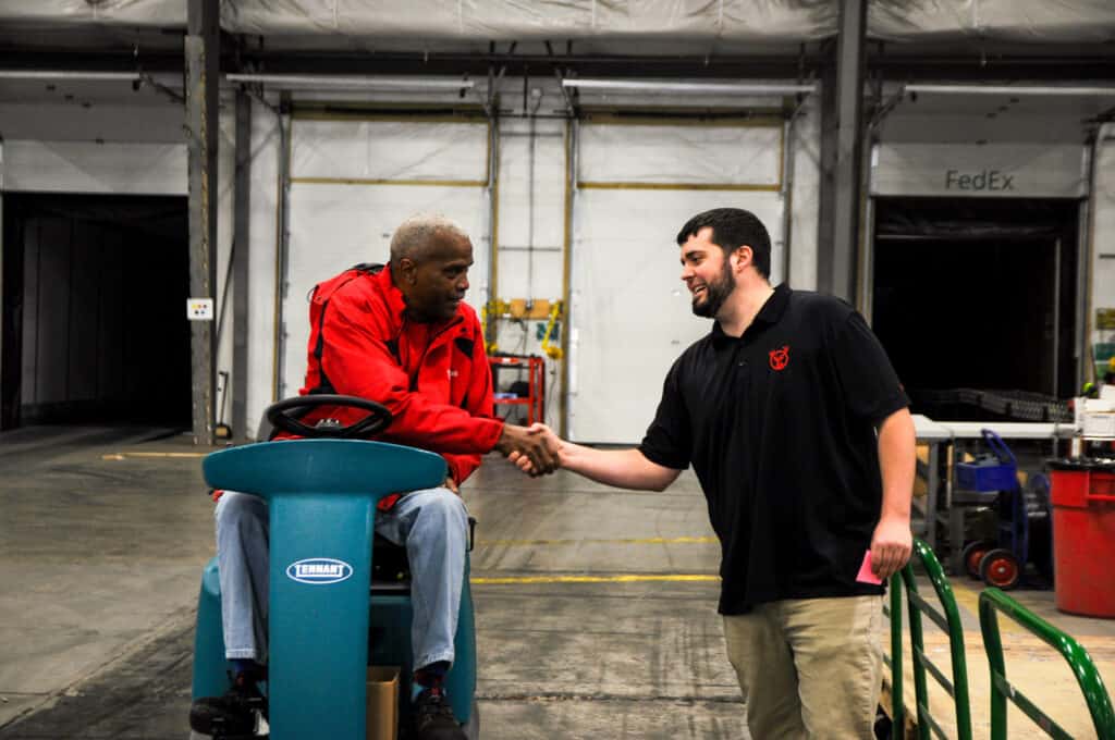 warehouse associates share a handshake